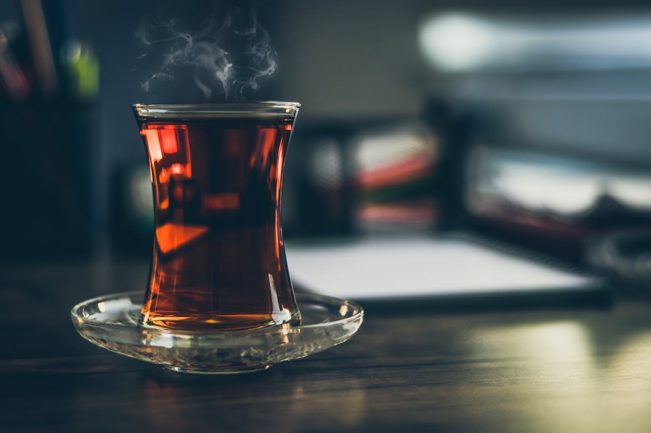 about-02 Close-up of steaming Turkish tea in a traditional glass, creating a cozy and inviting atmosphere.