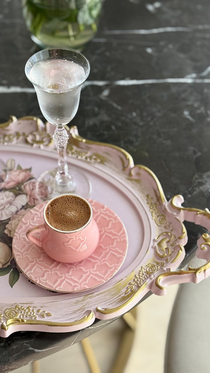 services-02 A stylish coffee cup and glass of water on a decorative floral tray.