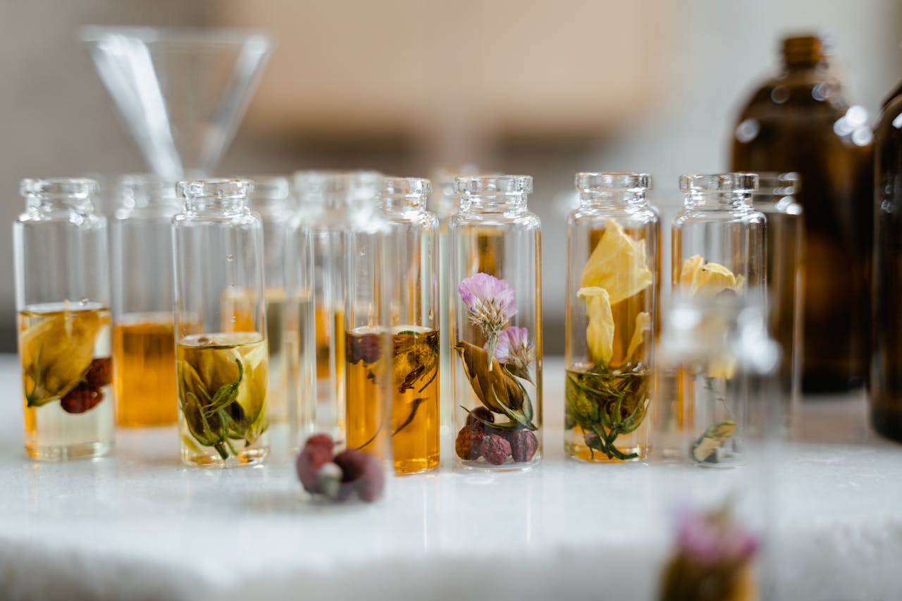 our-journey-01 Collection of glass bottles with dried flowers and liquid, ideal for aromatherapy